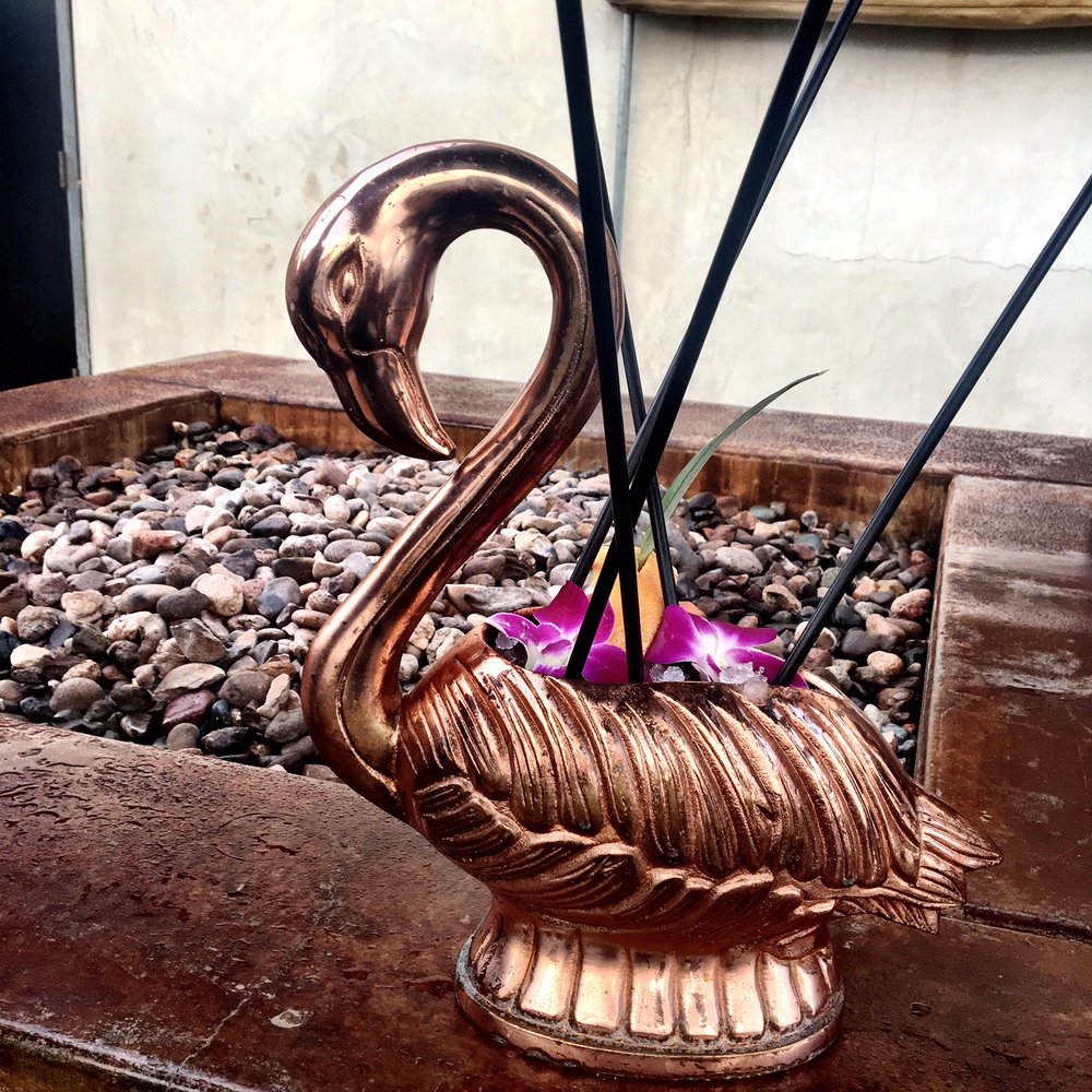 rum cocktail out of a rose gold flamingo at miss b's coconut club san diego