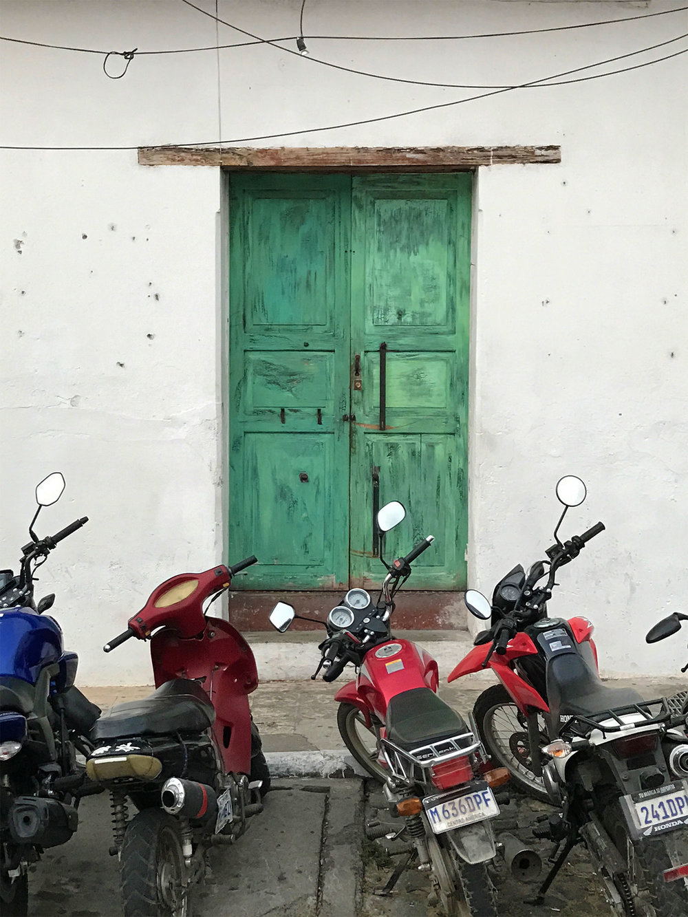 blue door and motor bikes in Antigua, Guatemala